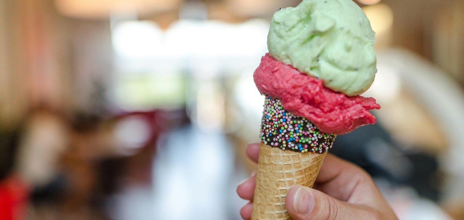 Close-up Photo of Person Holding Assorted-flavor Ice Cream on Cone