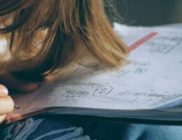 woman in blue denim jacket holding white paper