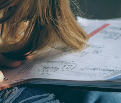 woman in blue denim jacket holding white paper