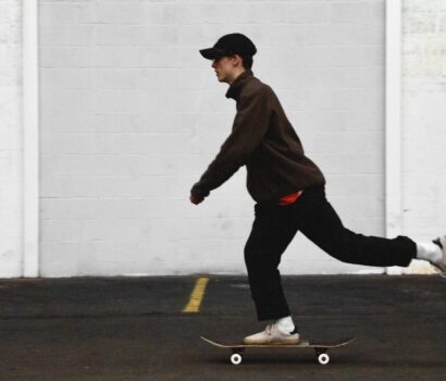 man in black pants and brown jacket riding skateboard