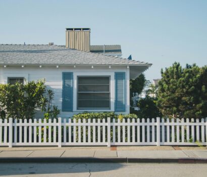 white and blue house beside fence