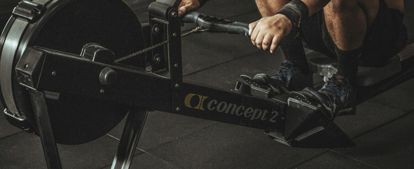 topless man using rowing machine