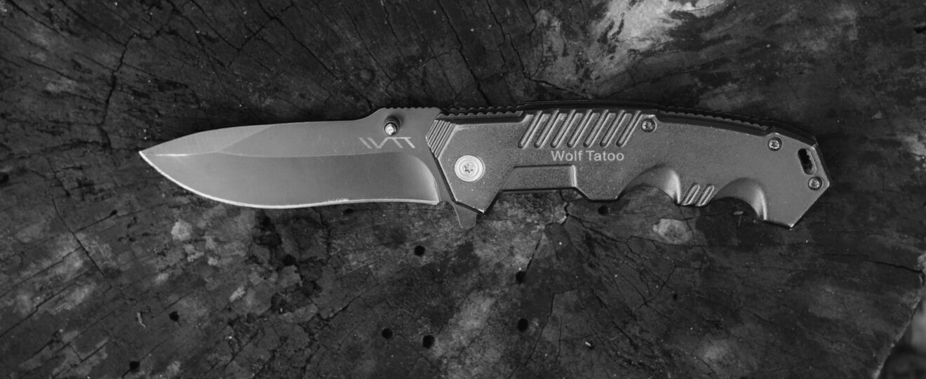 black handled knife on black and white surface