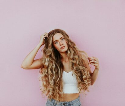 woman standing next to pink wall while scratching her head