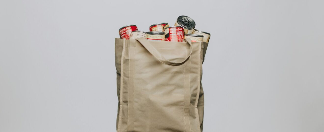 red labeled cans on white fabric handbag