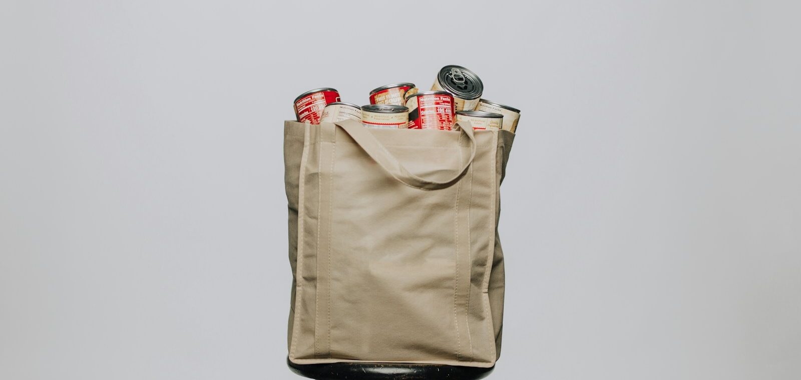 red labeled cans on white fabric handbag