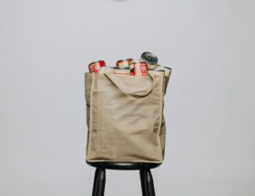 red labeled cans on white fabric handbag