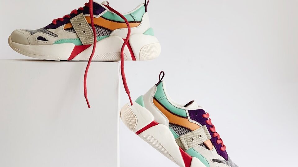 pair of white-and-orange athletic shoes on white box