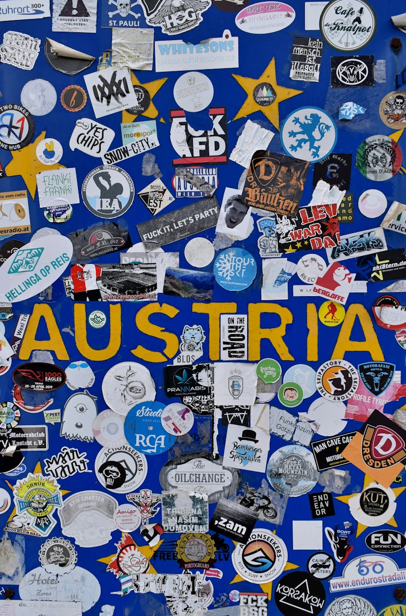 Blue wall covered in stickers with the word austria.